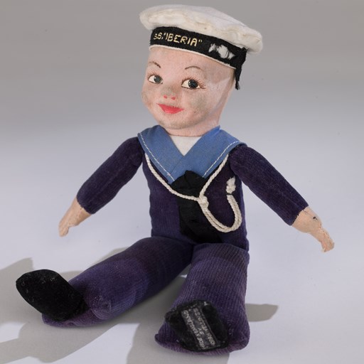 Cloth sailor doll, in a blue uniform with a white hat, bought as a souvenir on a ship voyage to Australia.