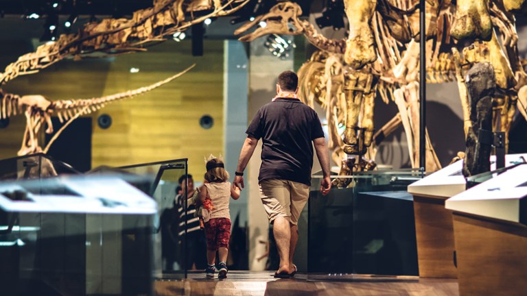 Family walking though the dinosaur walk at Museum Members Summer Party.