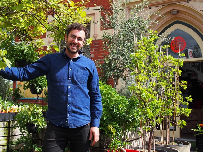 Mat Pember standing at his store outside, with plants in the background