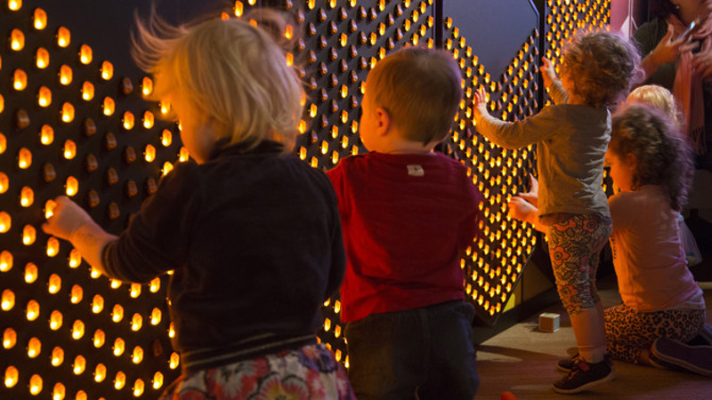 Children interacting with the Light Wall exhibit in the Ground Up exhibition