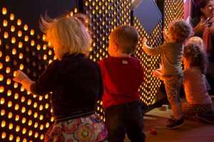Children interacting with the Light Wall exhibit in the Ground Up exhibition