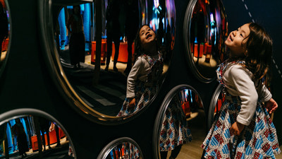 Child interacting with mirrors display in the Ground Up exhibition