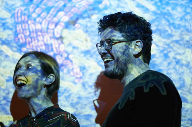 Man and a woman with animations projected over them