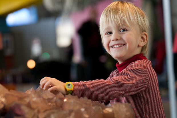 Child touching mineral on display in Children's Museum.