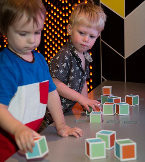 Boy playing with block shapes in Ground Up exhibition at Scienceworks.