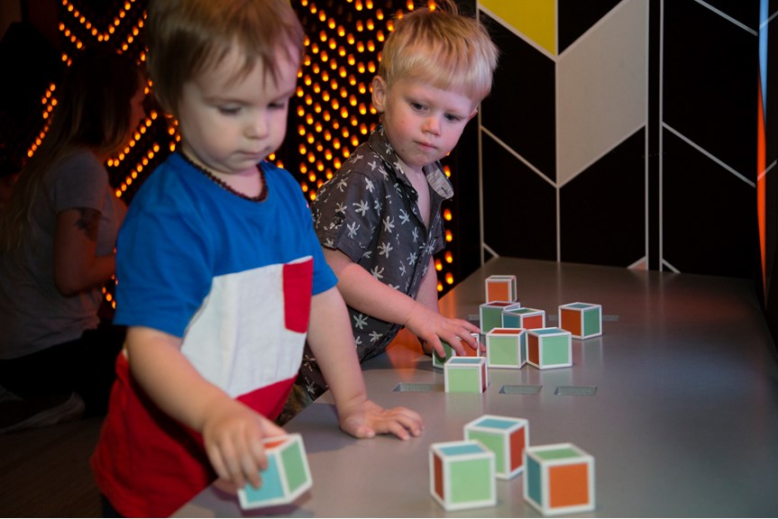 Boy playing with block shapes in Ground Up exhibition at Scienceworks.