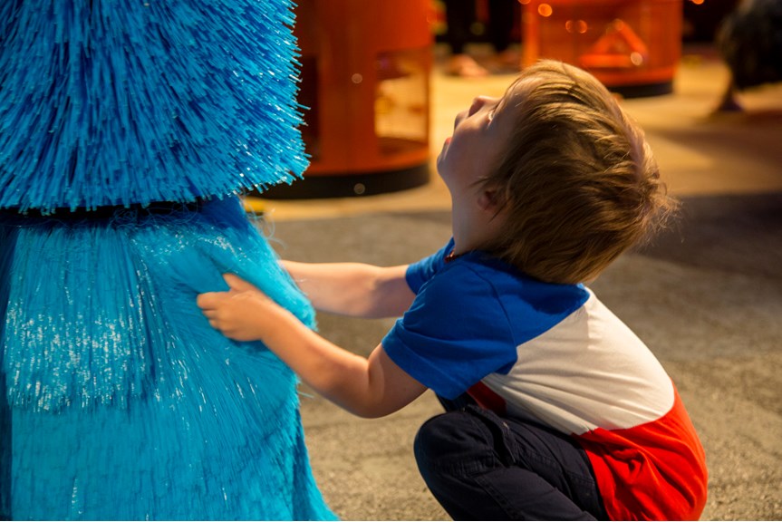 Boy touching soft blue brush interactive in Ground Up exhibition at Scienceworks. 