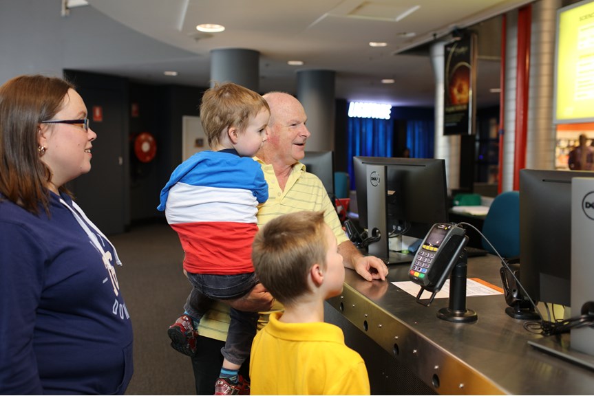 Family at the ticketing counter at Scienceworks. 