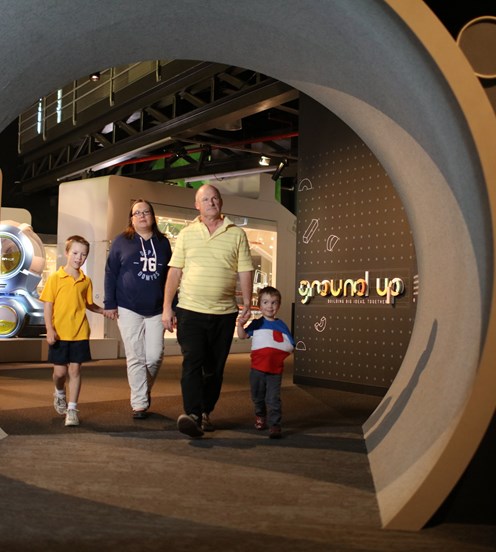 Family walking towards the entrance tunnel to the Ground Up exhibition at Scienceworks. 