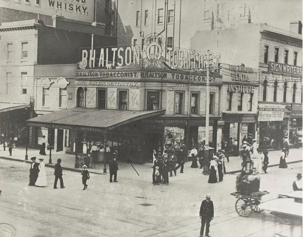 View from above of B H Altson Tobacconist, corner store on corner of Collins and Elizabeth Streets.This photograph shows a view of B H Altson Tobacconist, on the corner of Collins and Elizabeth Streets, Melbourne, circa 1890s. This was the original building that housed B H Alton's tobacco business, and according to the family, 'was the first brick building in Melbourne. It was replaced by a new building in 1903'.