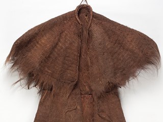 Field coat, cape style, made of vegetable fibre. The top of the coat forms a waist-length cape, drawn together and strongly bound at the neck. A cord extends from either side of the neck band.
