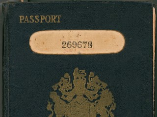 Blue card with gold stamped British coat of arms entitled 'Passport'; includes photo and personal details.