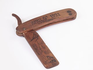 Large wooden cut-throat razor, with inscriptions on the handle and blade.