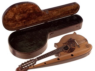Wooden case with metal clasps and lined with a dark brown fur on lid and a dark green fur on the bottom. Wooden Mandolin, made of various salvaged timbers, eccentric body shape with arm extending up the neck of the mandolin to the head, ending in a florentine scroll. Eight machine heads for four courses of strings; oval sound hole with tortoise shell inlay. Neck has 24 frets with six inlaid mother of pearl finger spots, head stock has mother of pearl inlay.