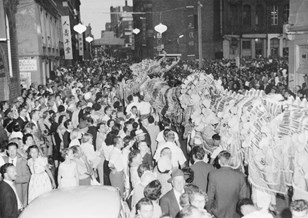 Chinese New Year celebrations in Little Bourke Street, Melbourne, 1960: a large crowd and a dragon procession coursing through it