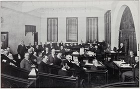 A room full of Victorian gentlemen in a municipal chamber
