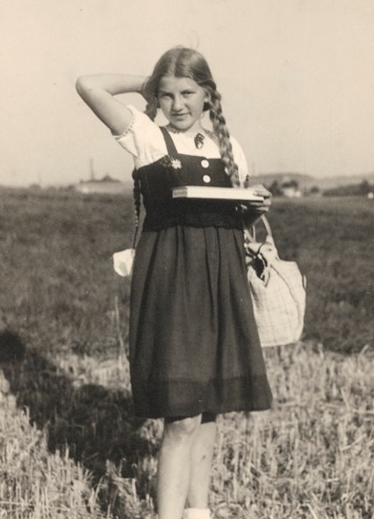 Black and white image of a girl standing in a field