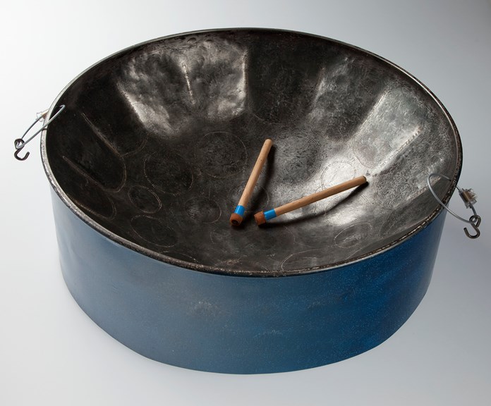 A steel pan with blue sides and a concave top with drum sticks on top of it