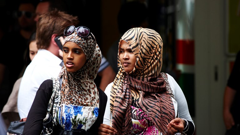 Two young women wearing animal print head scarves