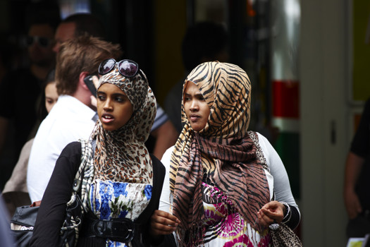 Two young women wearing animal print head scarves