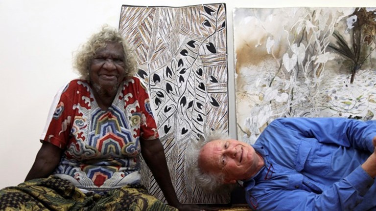 Artists Mulkuṉ​ Wirrpanda and John Wolseley pose in front of their work.