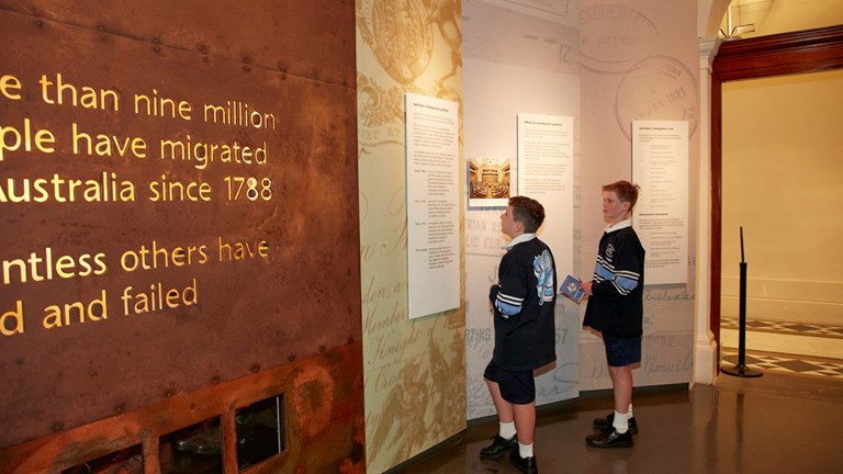 Two school boys reading an exhibition panel