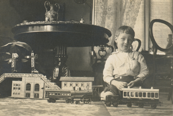John Wilton Twycross playing with a toy train, Emmarine II, Elsternwick, circa 1920.