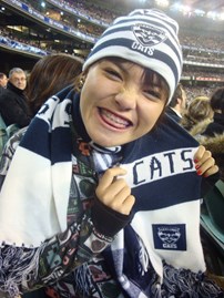 Woman with brace wearing geelong supporters beanie and scarf
