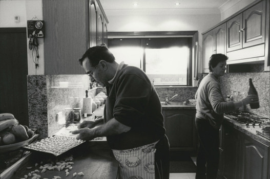 Black and white photograph of a man and woman cooking in a 1970s style kitchen