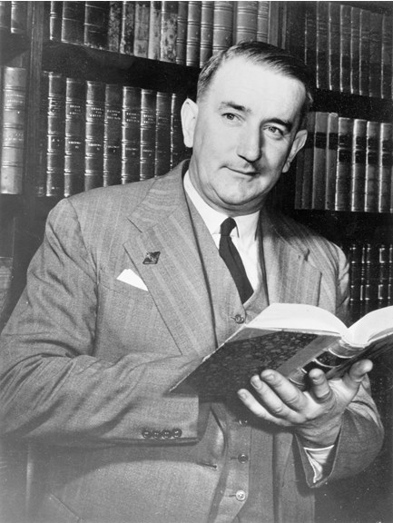 Black and white portrait of a man holding a book