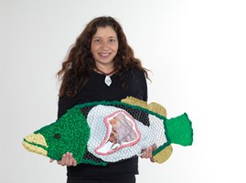 Artist Treahna Hamm holding her mixed media Murray cod