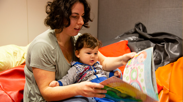  Family reading a First People's story in the Energy LAB, during the Little Kids Day In - Caring for Country.