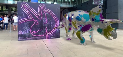 An augmented reality triceratops stands in the Melbourne Museum foyer