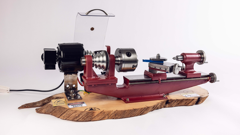 Red-painted metal lathe set atop a slice of Huon pine.