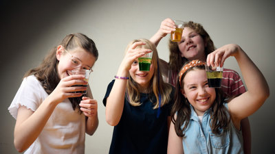 A group of young adults inspect the liquid in thier cups during a Science Studio workshop at Scienceworks.