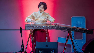 Qi playing a traditional Chinese instrument.