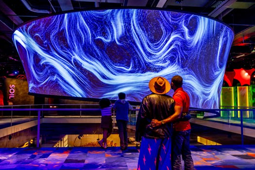 A family look at the large cylindrical projection centerpiece in Our Wondrous Planet at Melbourne Museum.