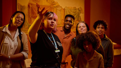 A tour guide talks about something out of view in ROME: Empire, People Power People Exhibition at Melbourne Museum