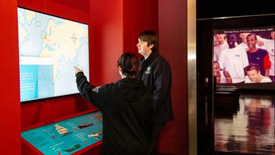  Secondary school students engaging with the interactive in the Leaving Home exhibition in Immigration Museum.