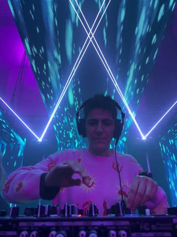 DJ Dub Darko djing with lights and lasers in the background.