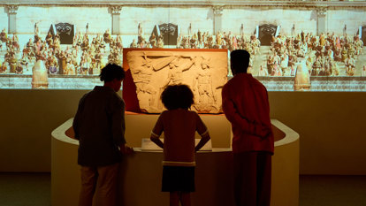 Children looking at a  roman carved relief depicting gladiators in ROME: Empire, People Power People Exhibition at Melbourne Museum