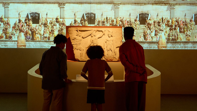 Children looking at a  roman carved relief depicting gladiators in ROME: Empire, People Power People Exhibition at Melbourne Museum