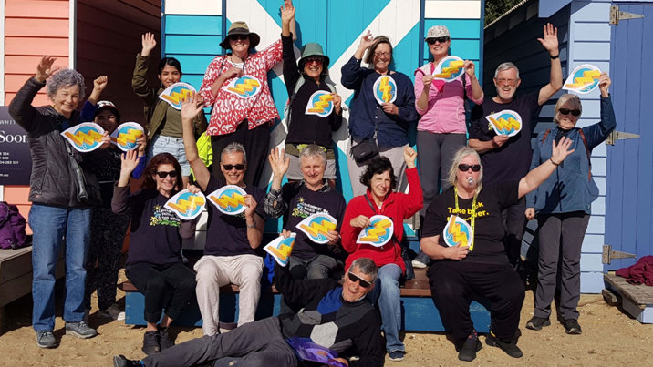 A group of people at a beach excited about renewable energgy