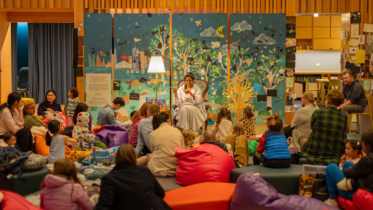 A woman reads childrens books to kids during a Story House Workshop at the State Library of Victoria.