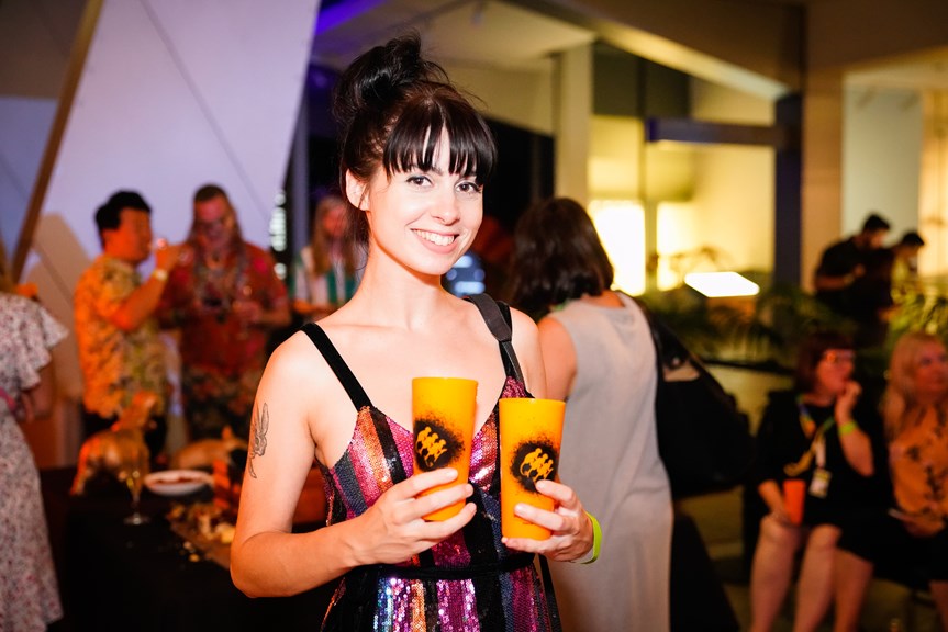 A woman carrying drinks at Nocturnal, Melbourne Museum.