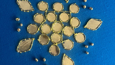 Golden embroidery pattern on deep blue fabric.