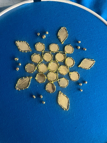 Golden embroidery pattern on deep blue fabric.