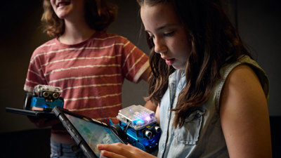 A young adult uses an iPad to program a robot as part of Robots and Coding workshop at Scienceworks.