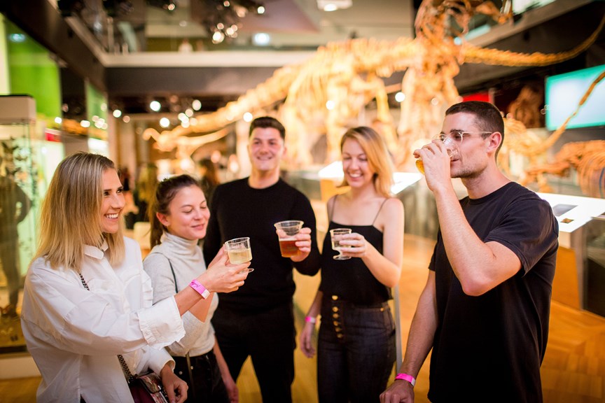 people cheering with drinks in the Dinosaur Walk.