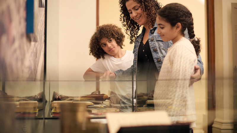 A young look at a display case in the Customs Gallery at the Immigration Museum.